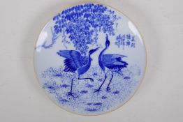 A Japanese blue and white porcelain cabinet plate decorated with cranes, inscription to the base,