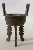 A Chinese archaic style bronze censer, with two handles, raised on tripod supports, 24cm high