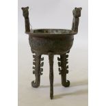 A Chinese archaic style bronze censer, with two handles, raised on tripod supports, 24cm high