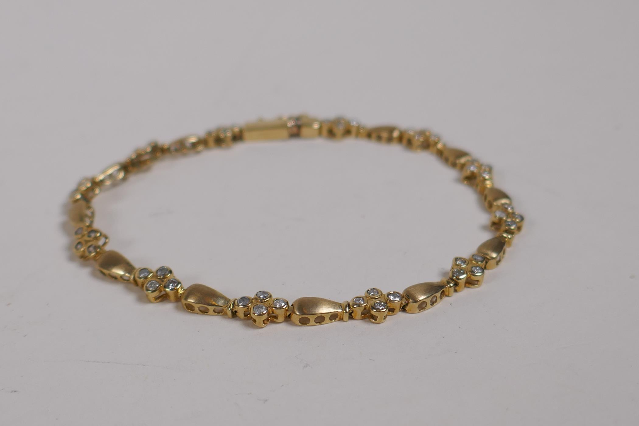 A 10ct yellow gold and diamond set line bracelet, 18cm long