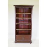 A mahogany open bookcase with cupboard to base, raised on bun feet, 95 x 34cm, 191cm high