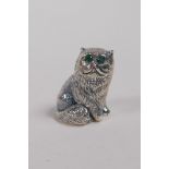 A sterling silver miniature figure of a cat with emerald set eyes, 2cm