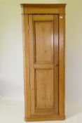 A C19th stripped pine standing corner cupboard, raised on a plinth base, 76 x 200cms