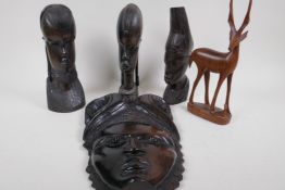 Three African carved ebony heads, 23cm high, a carved hardwood mask and a carved antelope