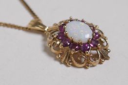A 9ct gold pendant set with an opal and pink stones, possibly topaz, on a gold chain, 4.9g
