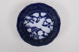 A Chinese blue ground dish of lobed form with white phoenix decoration, 18cm diameter