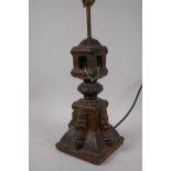 An Indian carved wood table lamp in the form of a temple with applied figural decoration, 44cm high