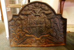 An antique cast iron fire back decorated with a coat of arms, 68 x 52cm