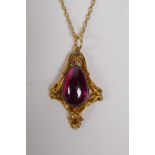 A yellow metal Art Nouveau style pendant on chain set with a purple coloured stone, 4cm long, 9.3g