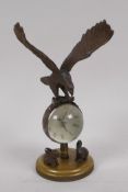 A desk top ball clock surmounted with a bronze figure of an eagle and two bronze rabbits to the
