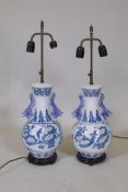 A pair of Chinese polychrome porcelain table lamps with twin dragon handles and decorative floral