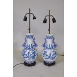 A pair of Chinese polychrome porcelain table lamps with twin dragon handles and decorative floral