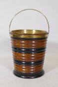 A fruitwood peat bucket with ebonised decoration, brass handle and liner, 33cm high