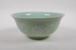 A celadon glazed porcelain bowl with raised white enamel floral decoration, Chinese Qianlong seal