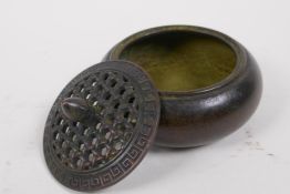 An oriental bronze censer with pierced cover, 10cm diameter