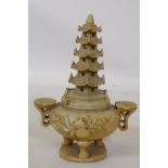 A Chinese soapstone censer with pagoda cover and ruyi handles, raised on tripod supports, 26cm high