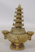 A Chinese soapstone censer with pagoda cover and ruyi handles, raised on tripod supports, 26cm high