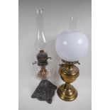 A Victorian oil lamp with cast iron base, glass font and duplex burner and glass funnel, together