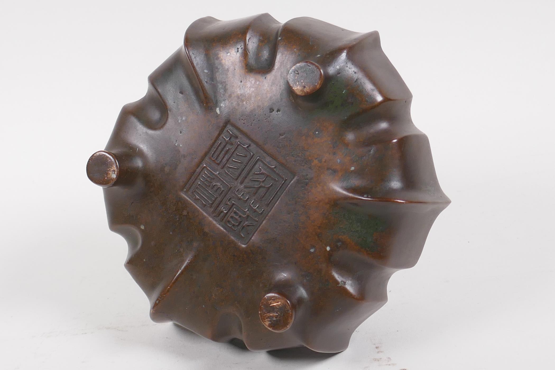 A Chinese lotus flower shaped bronze censer with loop handles on tripod supports, impressed - Image 4 of 5