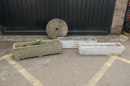 A pair of vintage Urastone garden troughs, a concrete trough and a millstone, 92cm long,