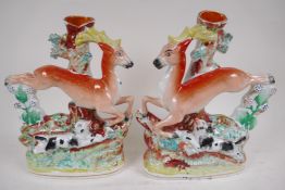 A pair of Staffordshire flat back spill vases modelled as stags and hounds, 29cm high