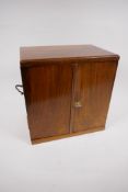 A walnut jewellery chest with two veneer matched doors revealing two short and two long drawers,