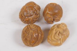 Four oriental nuts carved with Buddhist figures, 3cm diameter