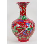 A Chinese porcelain vase decorated with dragons and phoenix on a red ground, 33cm high