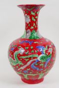 A Chinese porcelain vase decorated with dragons and phoenix on a red ground, 33cm high