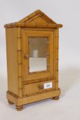A French pine model of an armoire with mirrored door and drawer and faux bamboo mouldings, 34cm high