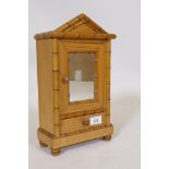 A French pine model of an armoire with mirrored door and drawer and faux bamboo mouldings, 34cm high