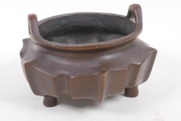 A Chinese lotus flower shaped bronze censer with loop handles on tripod supports, impressed