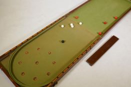 A C19th mahogany cased folding bagatelle table with baize lined interior and various balls, AF 2