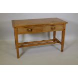 A pine two drawer scullery table with cleated top, raised on square tapering supports, united by