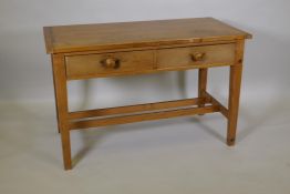 A pine two drawer scullery table with cleated top, raised on square tapering supports, united by