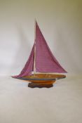 A wood model of a yacht, mounted on a stand, 125cm long, 142cm high