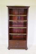 A mahogany open bookcase with cupboard to base, raised on bun feet, 95 x 34cm, 191cm high