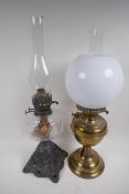 A Victorian oil lamp with cast iron base, glass font and duplex burner and glass funnel, together