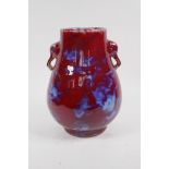 A Chinese blue and red flambe glazed porcelain vase with two elephant mask handles, 27cm high