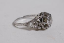 A platinum and diamond ring, set with a central stone, the pierced shoulders with three small