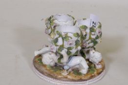 A Sitzendorf centrepiece of three putti bearing eggs, marked to base, AF losses, 8cm high