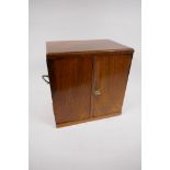 A walnut jewellery chest with two veneer matched doors revealing two short and two long drawers,