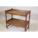 A mahogany two tier tea trolley with shaped galleries and turned supports, 74 x 78 x 43cms