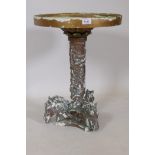 A painted parian style composition table with swivel top and raised classical decoration of a