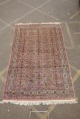 A Persian terracotta ground full pile wool carpet, decorated with an all over geometric design,