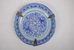 A C19th Chinese blue and white porcelain dish with lobed rim, metal straps and phoenix decoration,