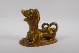 A late C19th/early C20th Turkish canakkale pottery lion, with yellow, green and brown drip glaze,