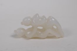 A Chinese carved white jade erotic pendant, 6cm long