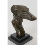 A stylised head bust of a greyhound mounted on a stepped marble base, 23cm high