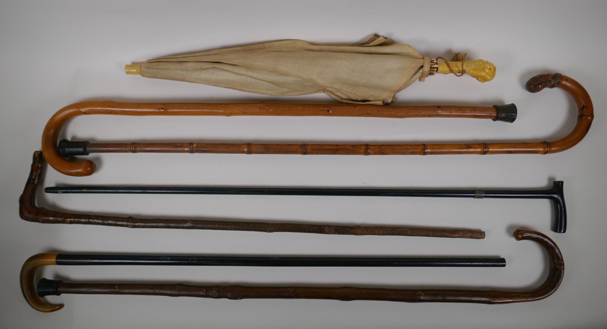 A collection of walking sticks including an ebonised stick with a hallmarked silver cuff, and a horn